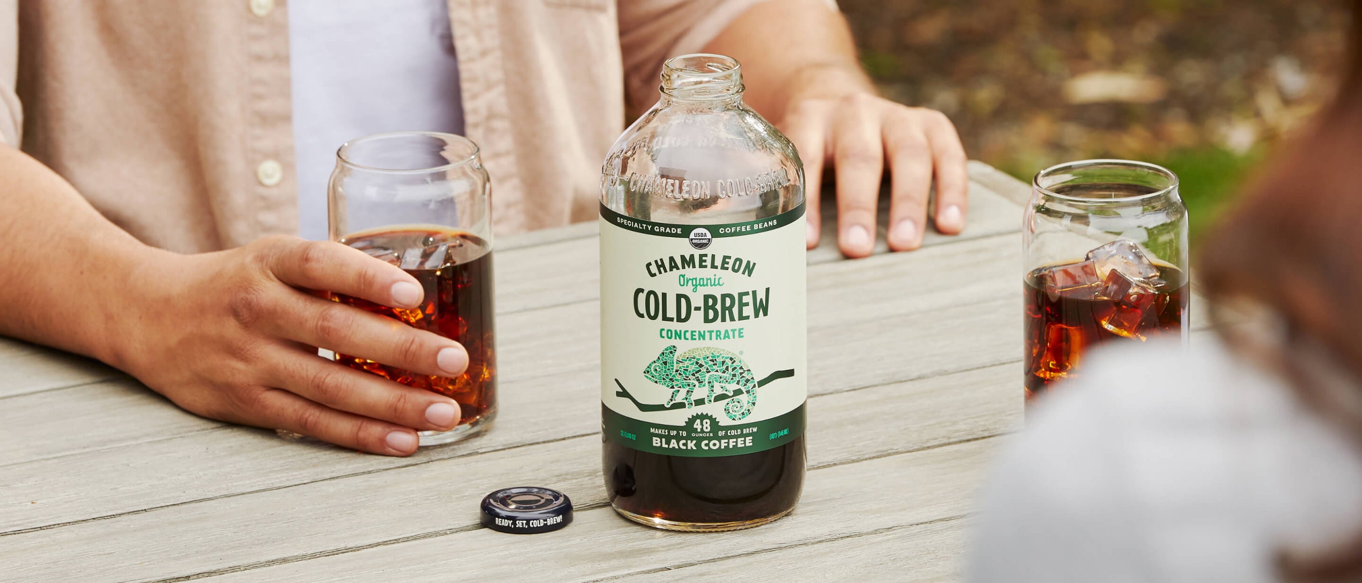 An image of a table with a bottle of black coffee placed on it, inviting you to savor its rich flavor.