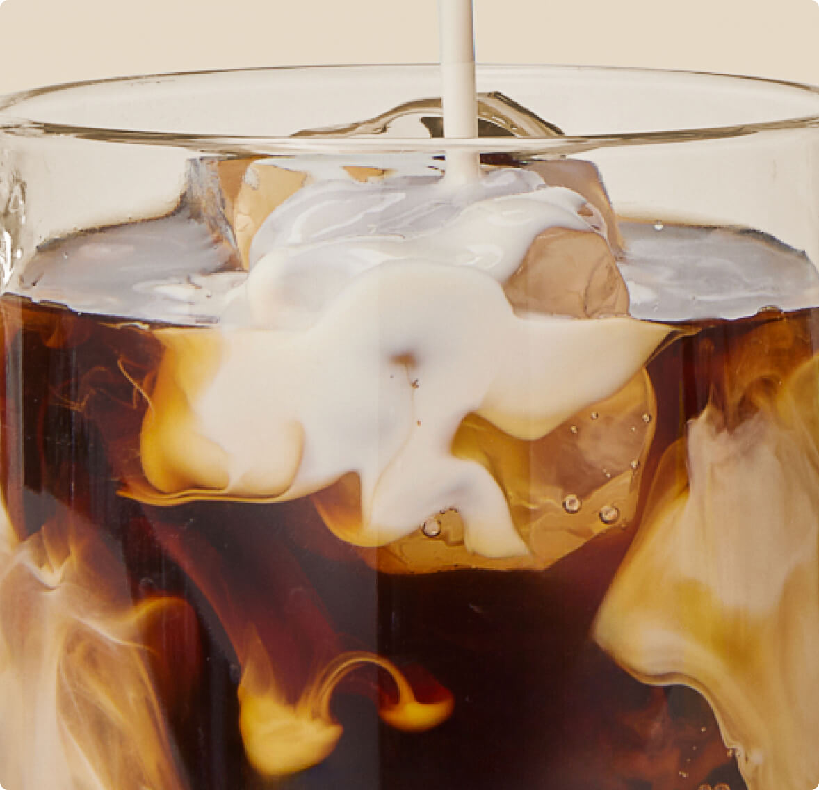 An image of a chilled glass of coffee with milk, served over ice cubes, offering a cool and creamy beverage.